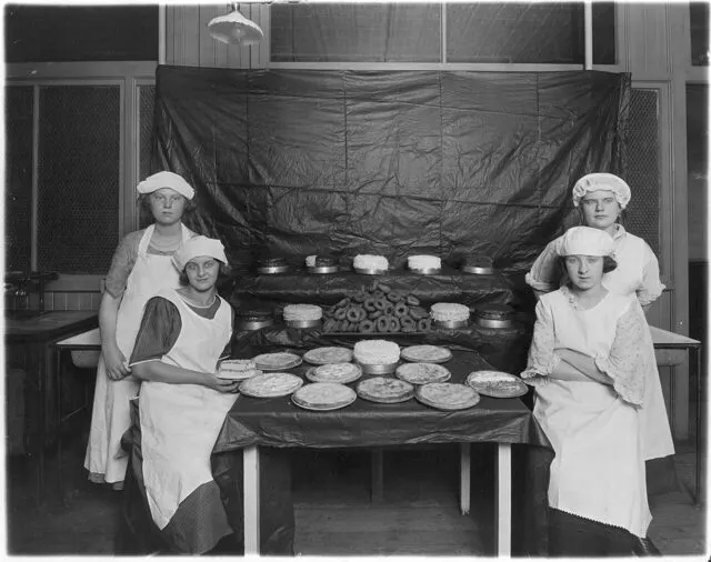 Historic photo of vocational school students with baked goods at an exhibit