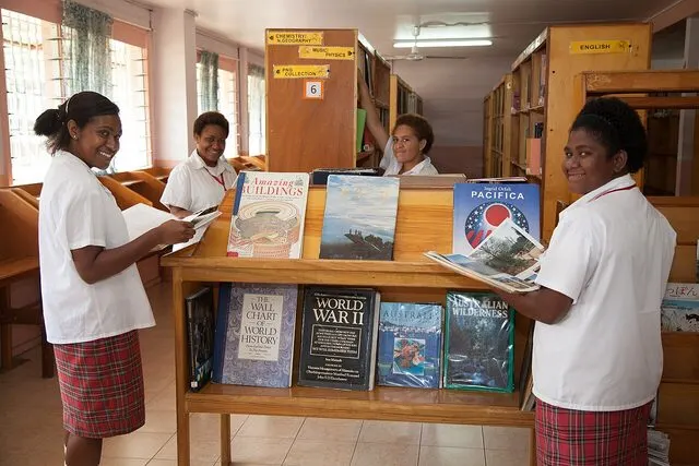 Students in school uniform reading in a technical secondary school library